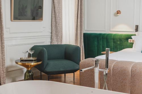 una habitación de hotel con una silla verde y una cama en Hôtel Singulier Bordeaux, en Burdeos