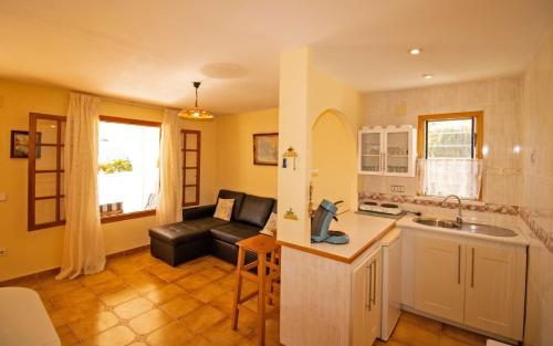 a kitchen and a living room with a couch at Villa privada a 350 metros del mar ALCOSSEBRE Albert Villas in Alcossebre