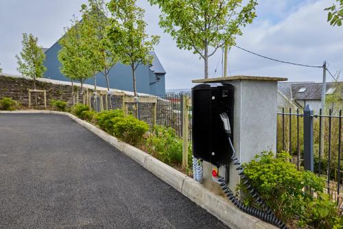 a pay phone sitting on the side of a fence at Perryville House in Kinsale