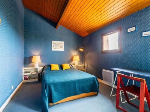 une chambre bleue avec un lit et une fenêtre dans l'établissement Apartment Le Bois du Roy by Interhome, à Saint-Palais-sur-Mer