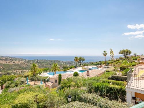 a view of a resort with a pool and the ocean at Apartment Le Petit Village-1 by Interhome in Les Issambres