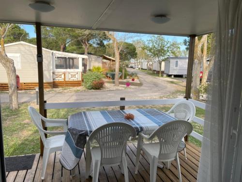 a table and chairs on the porch of a rv at Mobilhome au coeur de la Camargue in Le Grau-du-Roi