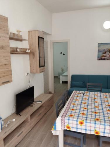 a living room with a table and a television at Terra del Sole - Valle in Ribera