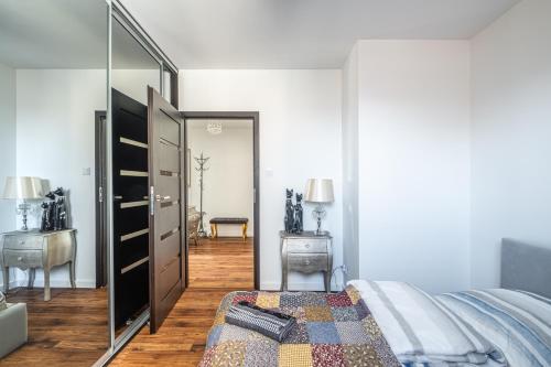 a bedroom with a bed and a large mirror at Apartament Kaskada Parking & Balcony by Axel in Gdynia