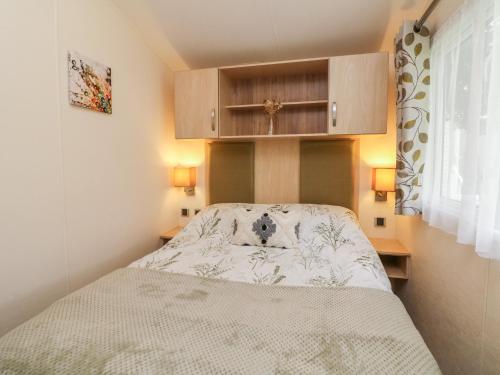 a small bedroom with a bed and cabinets at Ocean View in Ilfracombe