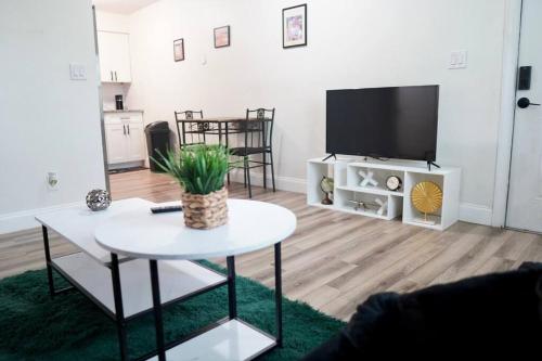 a living room with a table and a flat screen tv at Jay's Cozy Arts in Tampa