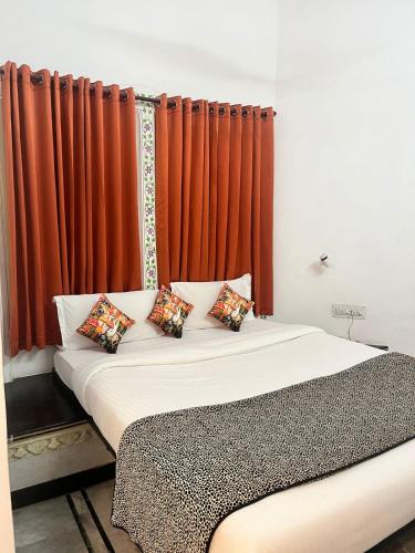 a bed in a room with an orange curtain at Hotel The Tiger in Udaipur