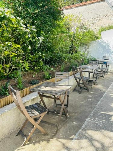 a group of tables and chairs sitting next to a wall at Castel Fleuri in Tours