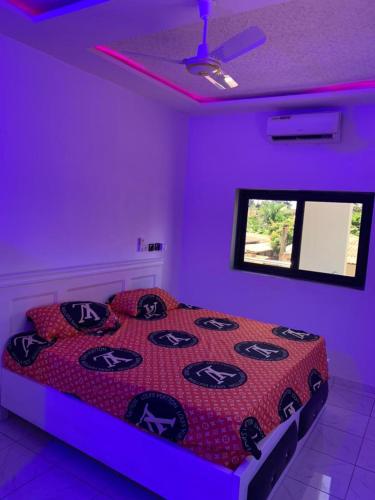 een slaapkamer met een bed in een paarse kamer bij BELLE VILLA LUXUEUSE in Baguida