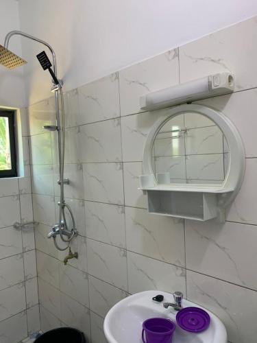 a bathroom with a sink and a mirror and a shower at BELLE VILLA LUXUEUSE in Baguida