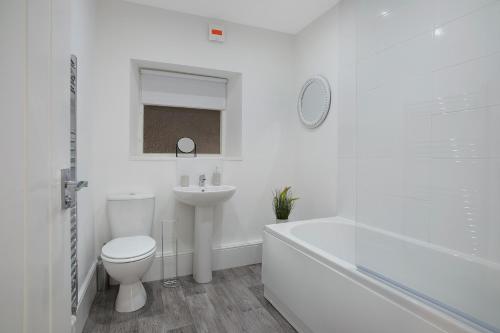 a white bathroom with a toilet and a sink at Feels like Home in Bishop, with Backyard, Sleeps 3 in Bishop Auckland