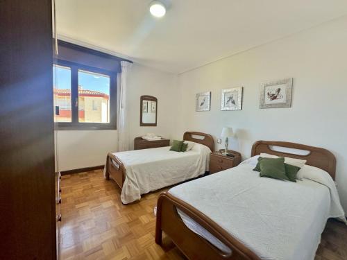 1 dormitorio con 2 camas y ventana en El Puentuco - 31001 en Loredo