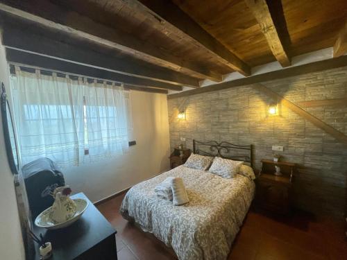 1 dormitorio con cama y pared de ladrillo en Finca - Granja " El Chaparral", en Orgaz