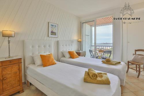 une chambre avec deux lits et un balcon dans l'établissement Antares - Appartement vue mer - Les sables, à Les Sables-dʼOlonne