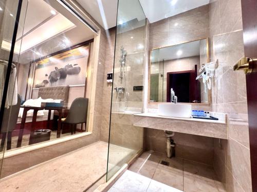 a bathroom with a sink and a glass shower at 怡程酒店ECHENG HOTEL in Sihanoukville