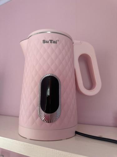 a pink toaster sitting on top of a counter at La vita hospedaria (Quarto Rosa) in Nova Veneza