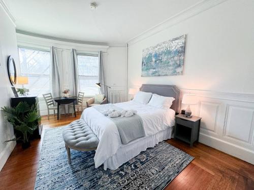 a white bedroom with a bed and a table at Pvt Room, St Marys, Fenway, Longwood, Green Line in Brookline