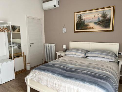 een slaapkamer met een bed en een schilderij aan de muur bij Orchidea in Modena