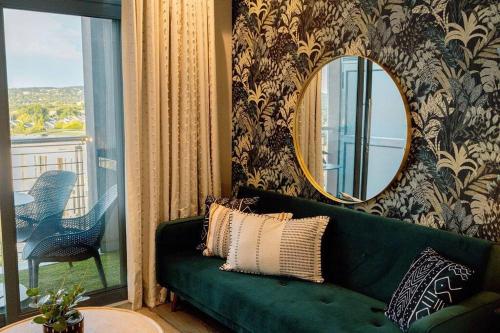 a green couch in a living room with a mirror at Luxury Menlyn Maine Apartment in Pretoria
