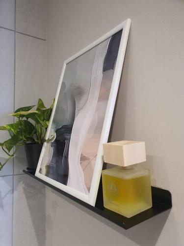 a shelf with a box and a candle and a plant at Luxury Menlyn Maine Apartment in Pretoria