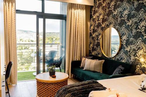 a living room with a green couch and a large window at Luxury Menlyn Maine Apartment in Pretoria