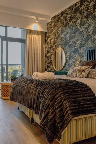 a bedroom with a large bed and a mirror at Luxury Menlyn Maine Apartment in Pretoria