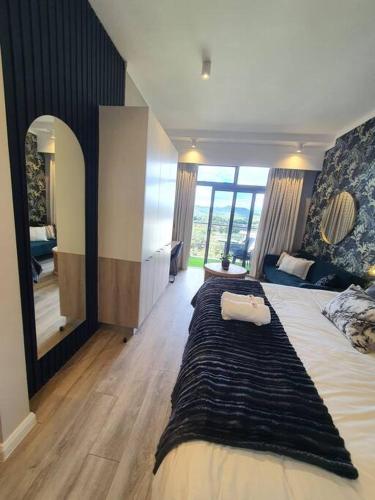 a bedroom with a large bed and a large mirror at Luxury Menlyn Maine Apartment in Pretoria