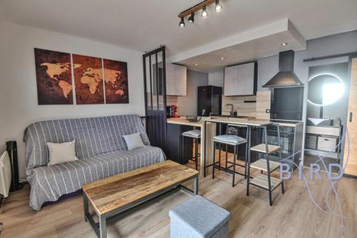 un salon avec un canapé et une cuisine dans l'établissement Large studio with swimming pool and open view, à Saint-Laurent-du-Var