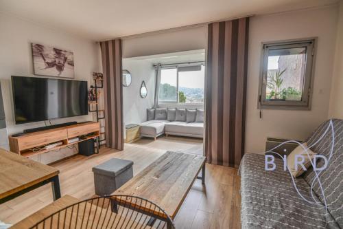 un salon avec une télévision et un canapé dans l'établissement Large studio with swimming pool and open view, à Saint-Laurent-du-Var