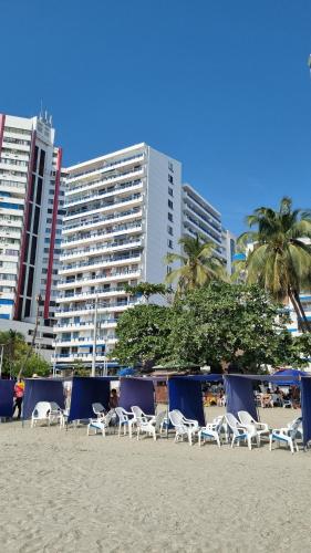 una fila de sillas en una playa con edificios en Balcón del Rodadero, en Santa Marta