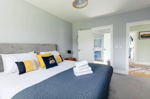 a bedroom with a large bed with yellow and blue pillows at Beautiful Modern Home In Dingle 5 min walk to town in Dingle