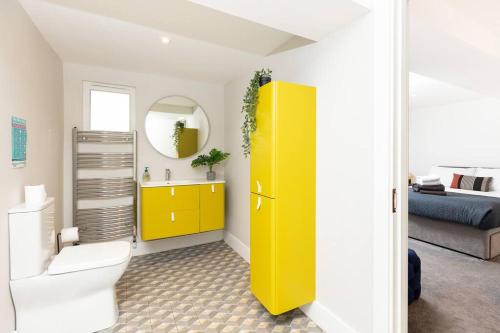 a bathroom with a toilet and a yellow cabinet at Beautiful Modern Home In Dingle 5 min walk to town in Dingle