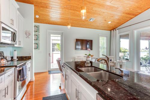 a kitchen with white cabinets and a wooden ceiling at Waterfront Stuart Oasis with Hot Tub and Dock! in Stuart