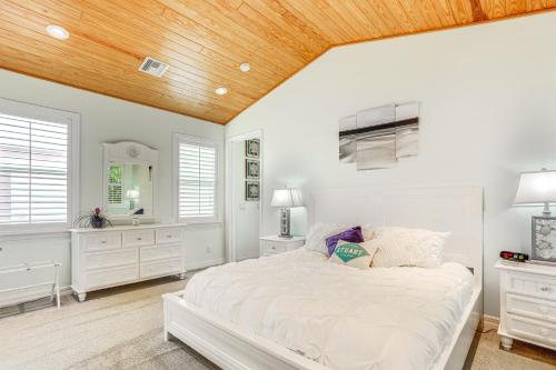 a bedroom with a white bed and a wooden ceiling at Waterfront Stuart Oasis with Hot Tub and Dock! in Stuart