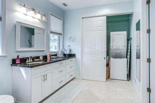 a white bathroom with a sink and a refrigerator at Waterfront Stuart Oasis with Hot Tub and Dock! in Stuart