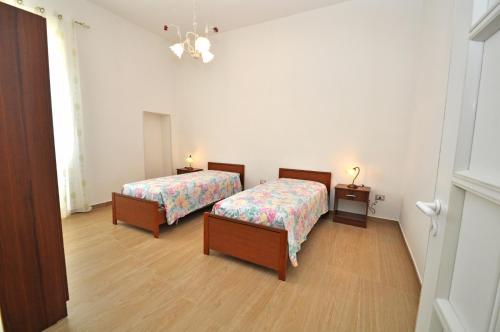 CapilungoにあるVilletta Assuntaのベッド2台とナイトスタンドが備わる客室です。