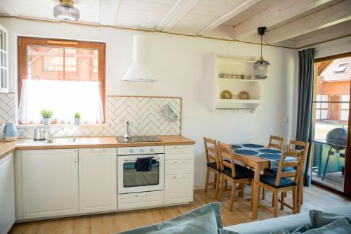 een keuken met een tafel en een eetkamer bij Biały Bez Ostoja Bukowo in Borowy Młyn