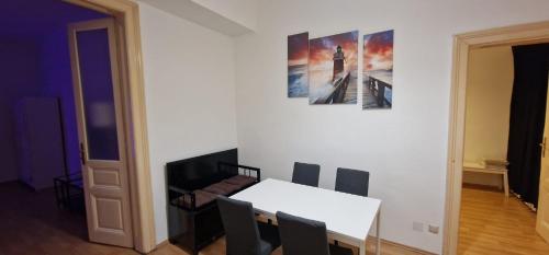 een eetkamer met een witte tafel en stoelen bij Weberknecht Apartments in Wenen