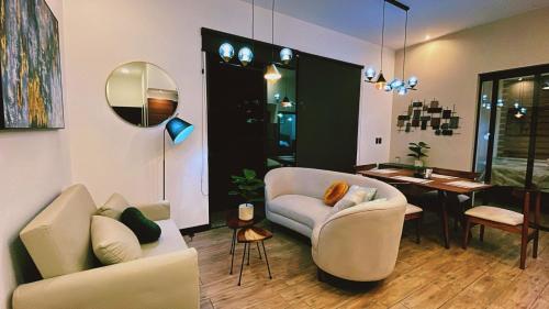 a living room with two chairs and a table at Luxury Penthouse EON Ciudad Guatemala zona 10 in Guatemala