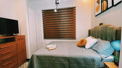 a small bedroom with a bed and a television at Luxury Penthouse EON Ciudad Guatemala zona 10 in Guatemala