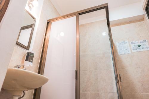 a shower with a glass door in a bathroom at Hotel Don Nino in Oaxaca City