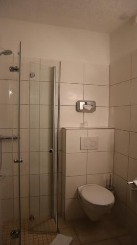 a bathroom with a toilet and a shower at Hotel Gasthaus zur Linde in Seevetal