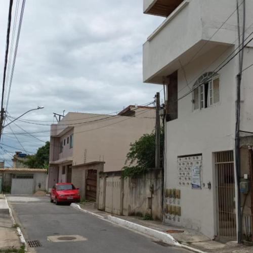 um carro vermelho estacionado ao lado de um edifício branco em Residencial Barbosa - Apto 102 em Macaé