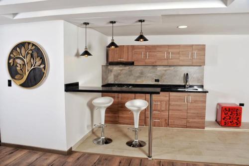 a kitchen with wooden cabinets and a black counter top at El Encanto Hotel Boutique in Duitama