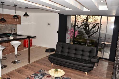 a living room with a black couch and a table at El Encanto Hotel Boutique in Duitama