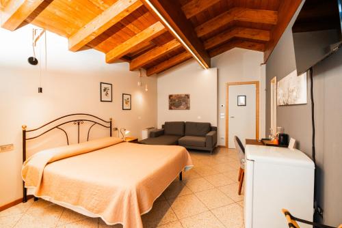 a bedroom with a bed and a couch at Agriturismo dei Grippi in Sona