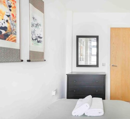 een slaapkamer met een bed met een spiegel en een dressoir bij Spacious 2 Bedroom Apartment In Central Near tube in Londen