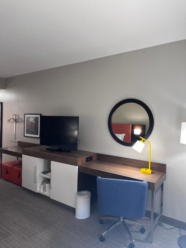 a room with a desk with a mirror and a chair at Hampton Inn & Suites Tallahassee I-10-Thomasville Road in Tallahassee