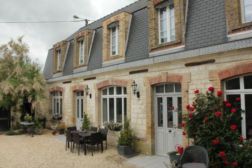 una casa con una mesa y sillas frente a ella en Le Presbytère de Sévigny, en Sévigny-Waleppe