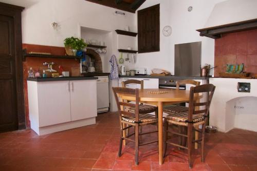 une cuisine avec une table et des chaises en bois dans l'établissement Casa di Pruno, à Morsiglia